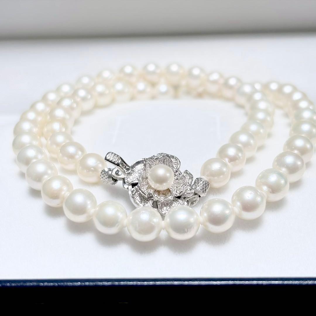 Akoya genuine pearl necklace with 6.4-6.9mm white pearls and silver SV clasp laid out on a white background