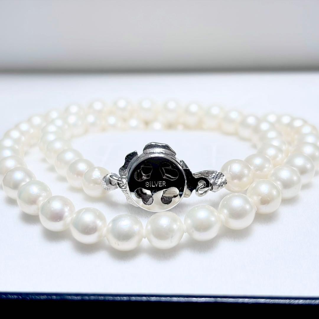 Akoya genuine pearl necklace with 6.4-6.9mm white pearls and silver SV clasp laid out on a white background
