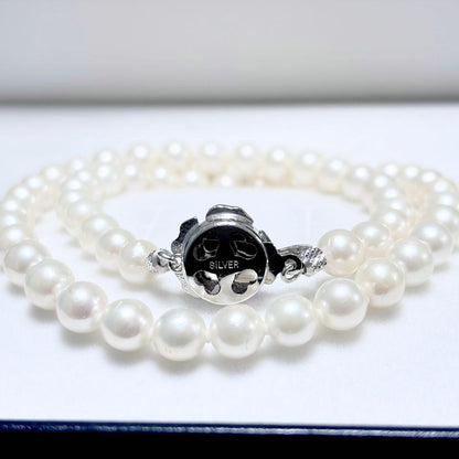 Akoya genuine pearl necklace with 6.4-6.9mm white pearls and silver SV clasp laid out on a white background