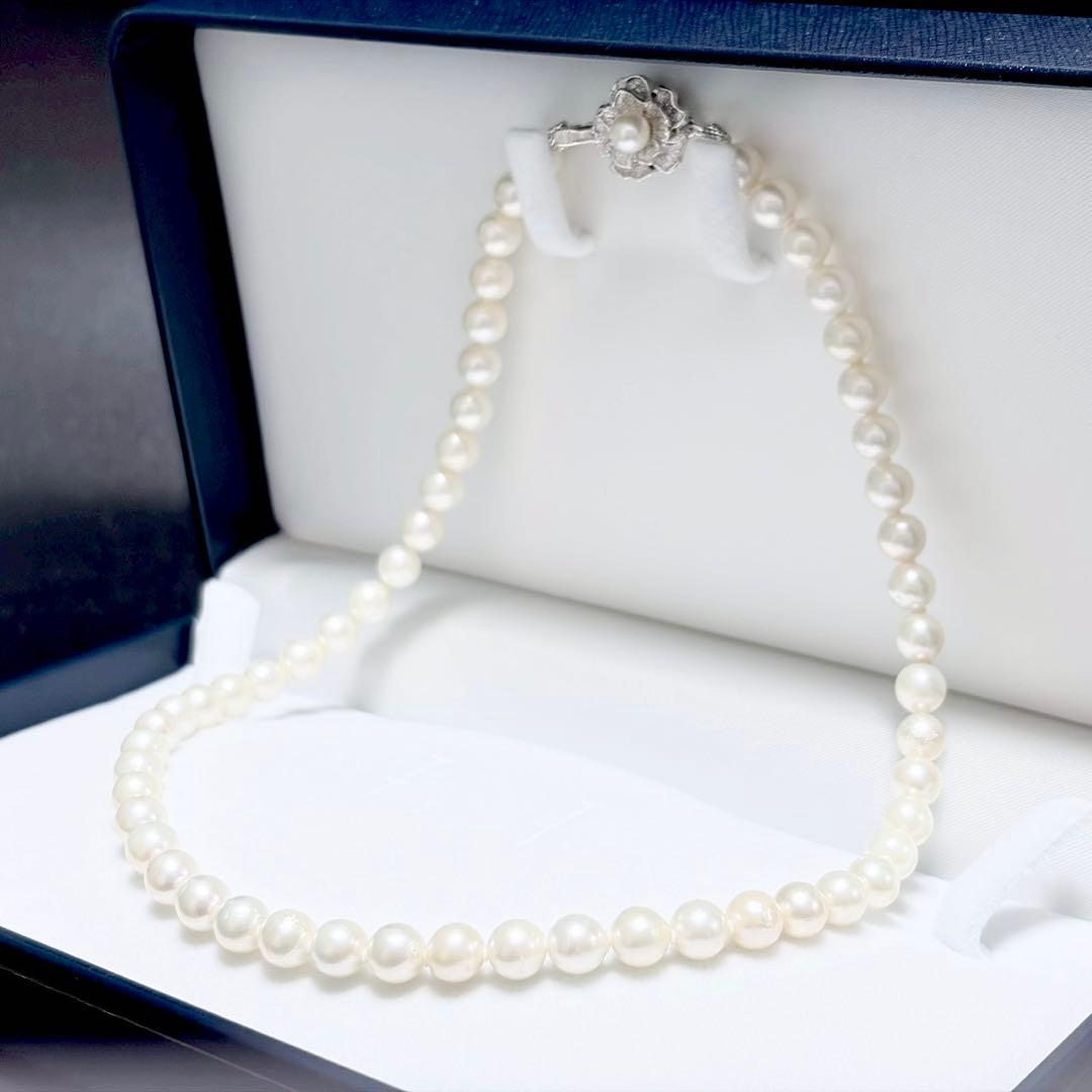 Akoya genuine pearl necklace with 6.4-6.9mm white pearls and silver SV clasp laid out on a white background