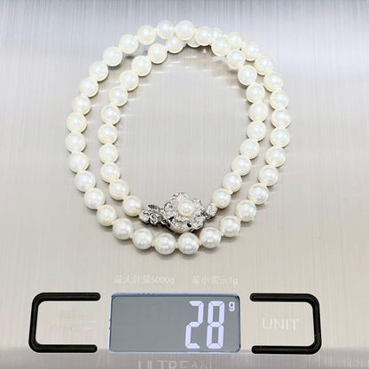 Akoya genuine pearl necklace with 6.4-6.9mm white pearls and silver SV clasp laid out on a white background
