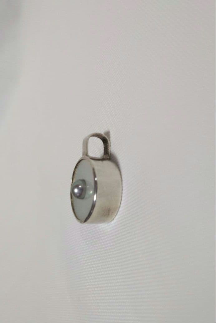 agete SV charm with white mother-of-pearl and gray freshwater pearl on a white background