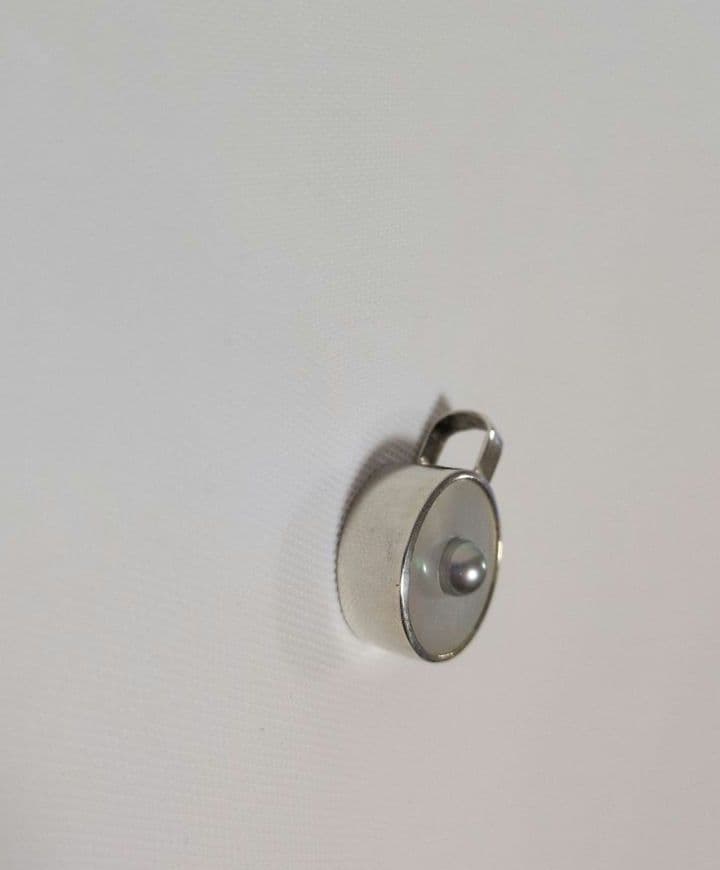 agete SV charm with white mother-of-pearl and gray freshwater pearl on a white background
