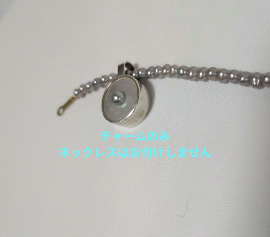 agete SV charm with white mother-of-pearl and gray freshwater pearl on a white background