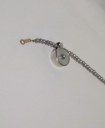 agete SV charm with white mother-of-pearl and gray freshwater pearl on a white background
