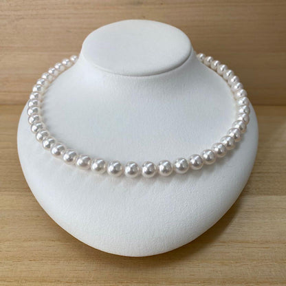 Akoya pearl necklace with 49 iridescent pearls sized 8.0-8.5mm and silver one-touch clasp on white background