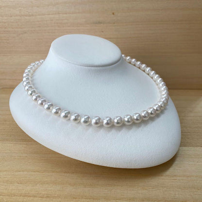 Akoya pearl necklace with 49 iridescent pearls sized 8.0-8.5mm and silver one-touch clasp on white background