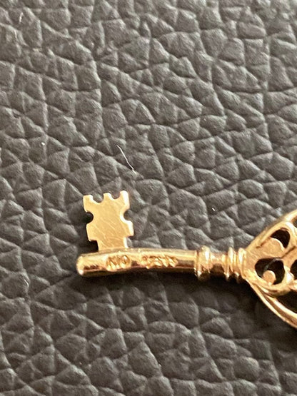 Agate K10 gold pendant top featuring a key motif in gold color