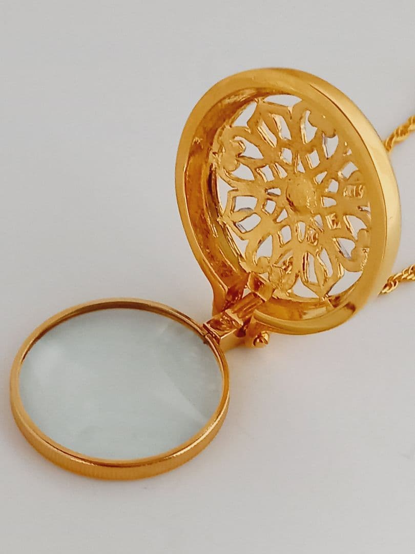 Mikimoto pendant necklace featuring a gold and silver pendant with magnifier on a 64 cm gold chain