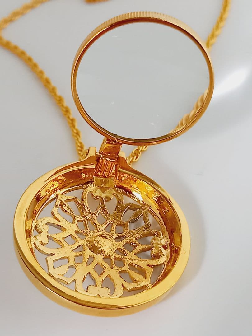 Mikimoto pendant necklace featuring a gold and silver pendant with magnifier on a 64 cm gold chain