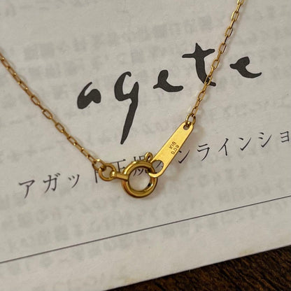 agete K18YG yellow gold diamond cross necklace with reversible milgrain design on a white background