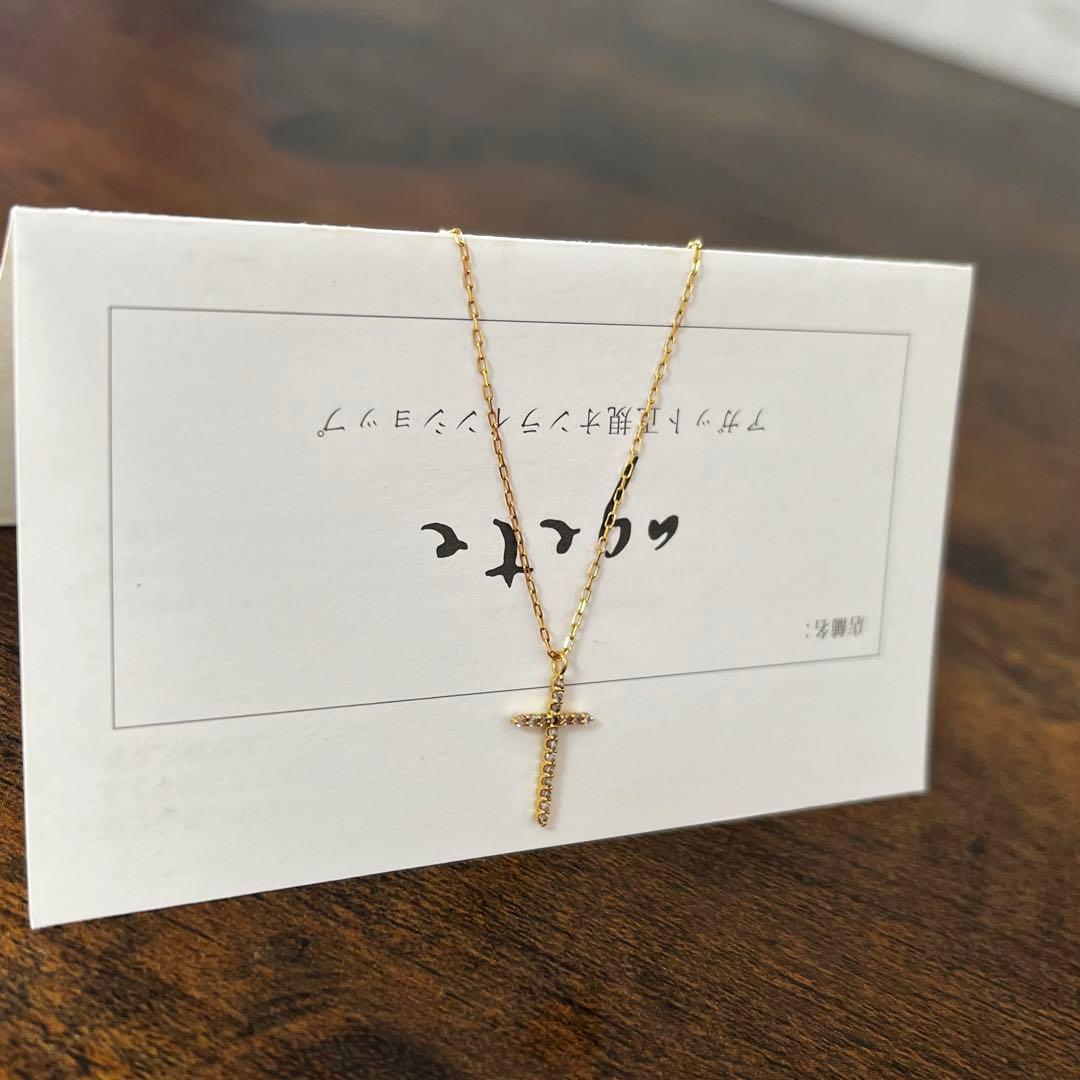 agete K18YG yellow gold diamond cross necklace with reversible milgrain design on a white background