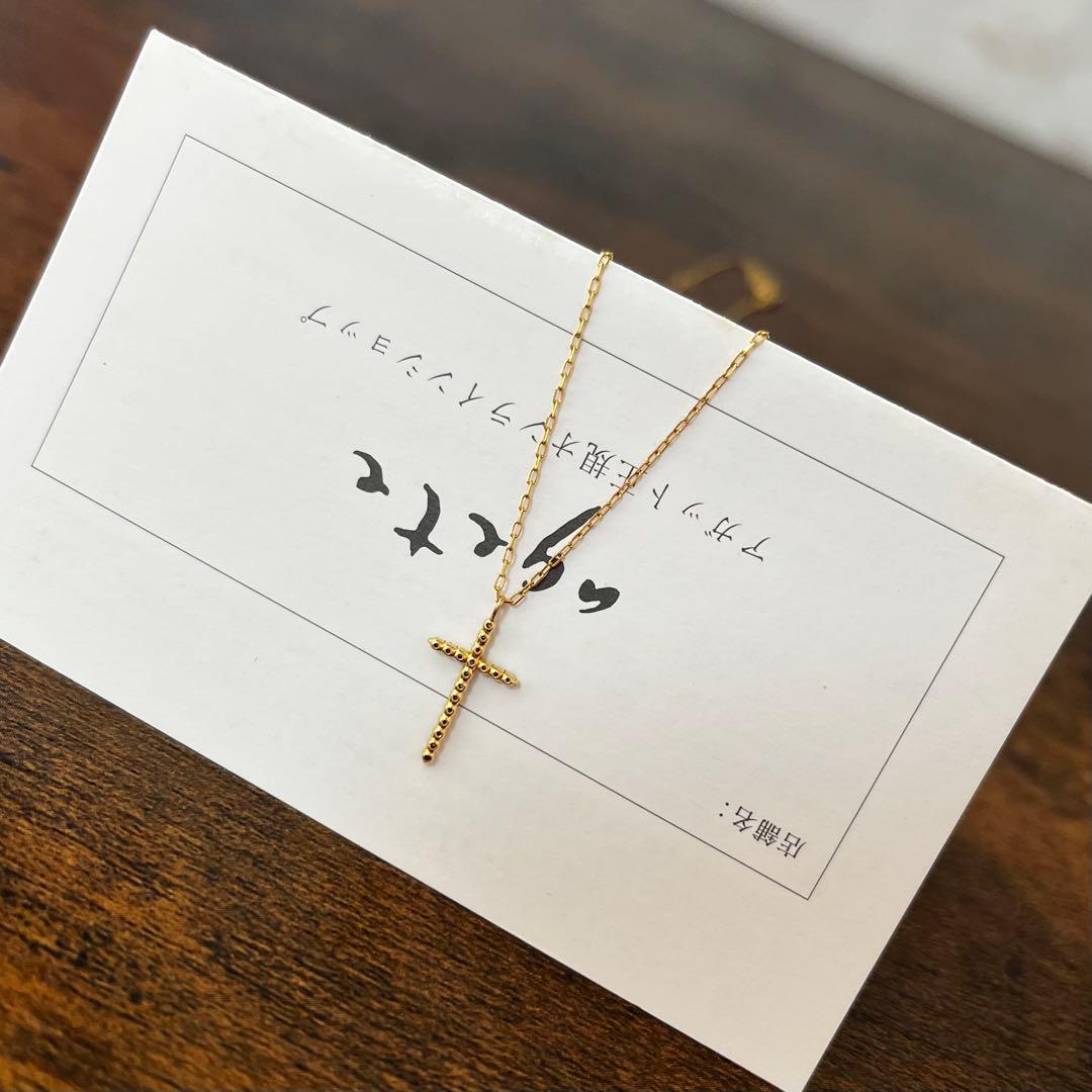 agete K18YG yellow gold diamond cross necklace with reversible milgrain design on a white background