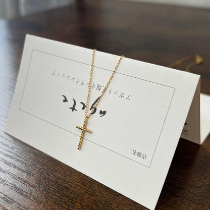 agete K18YG yellow gold diamond cross necklace with reversible milgrain design on a white background