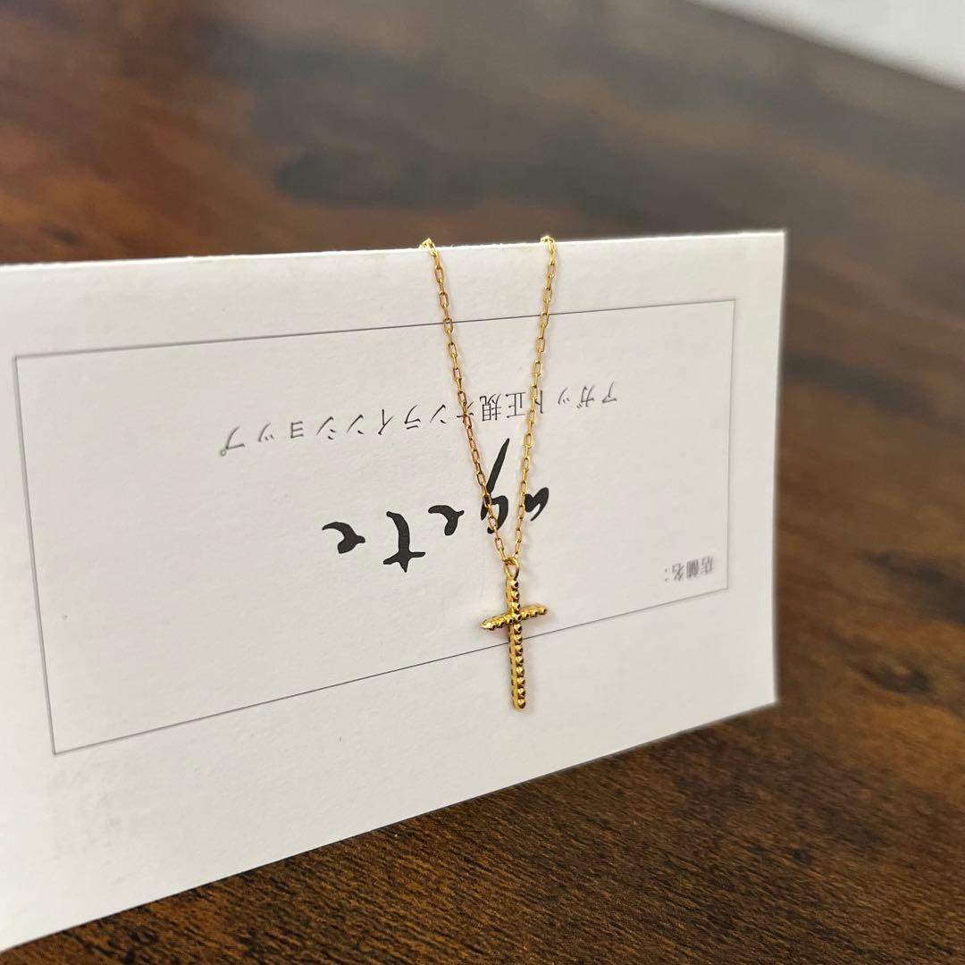 agete K18YG yellow gold diamond cross necklace with reversible milgrain design on a white background