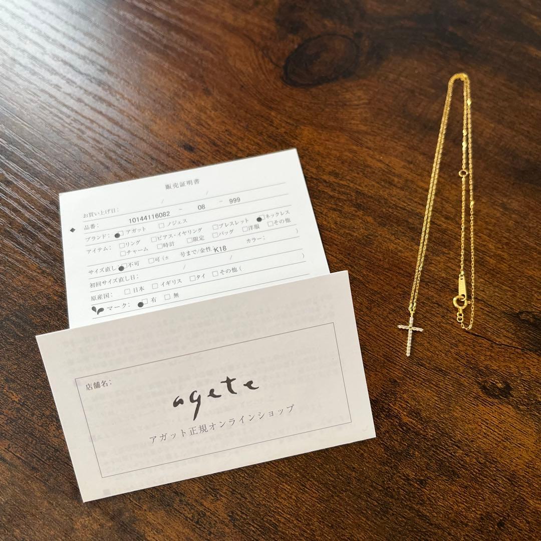 agete K18YG yellow gold diamond cross necklace with reversible milgrain design on a white background