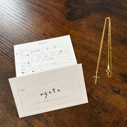 agete K18YG yellow gold diamond cross necklace with reversible milgrain design on a white background