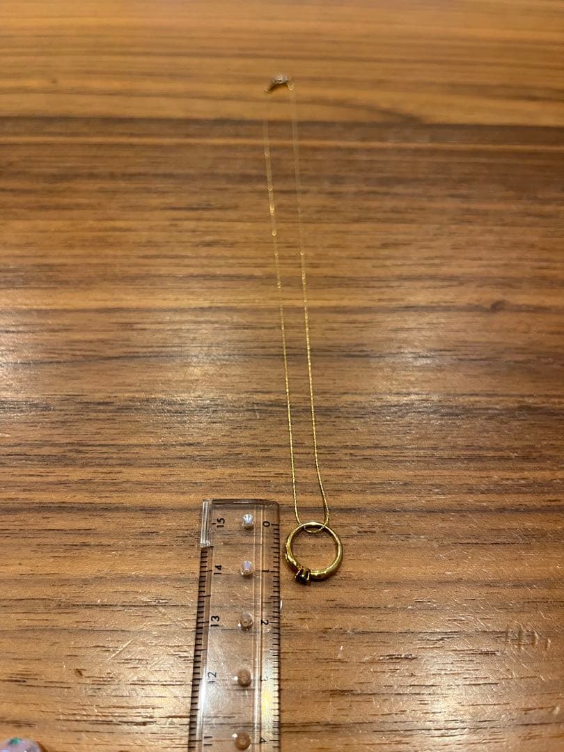 Mikimoto gold necklace with a sapphire pendant displayed on a white background