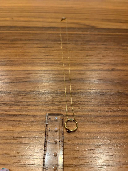 Mikimoto gold necklace with a sapphire pendant displayed on a white background