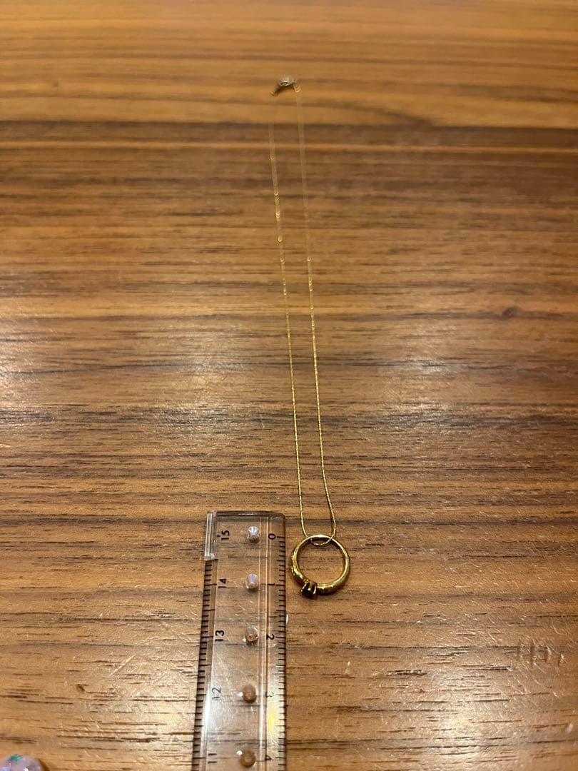 Mikimoto gold necklace with a sapphire pendant displayed on a white background