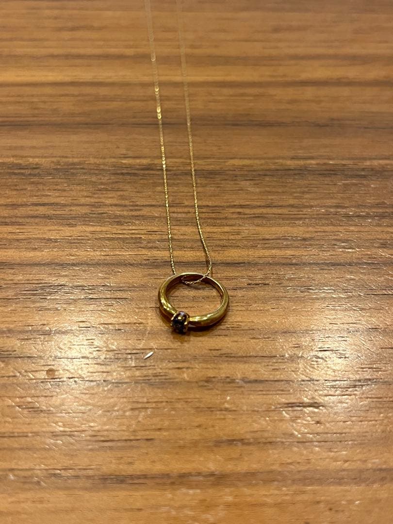 Mikimoto gold necklace with a sapphire pendant displayed on a white background
