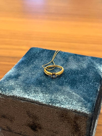 Mikimoto gold necklace with a sapphire pendant displayed on a white background