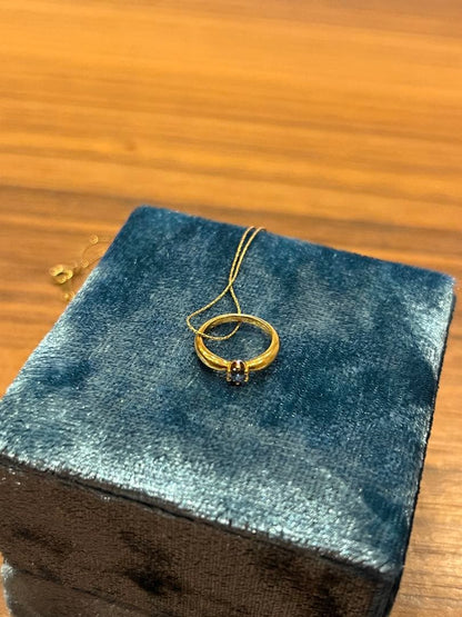 Mikimoto gold necklace with a sapphire pendant displayed on a white background