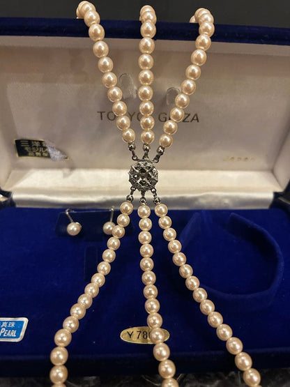 Akoya pearl three-strand beige necklace with matching earrings displayed on a white background