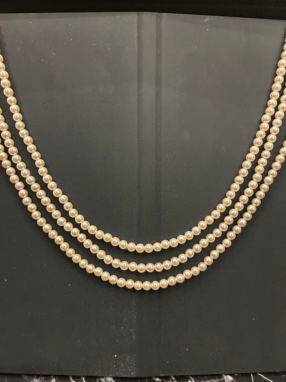 Akoya pearl three-strand beige necklace with matching earrings displayed on a white background