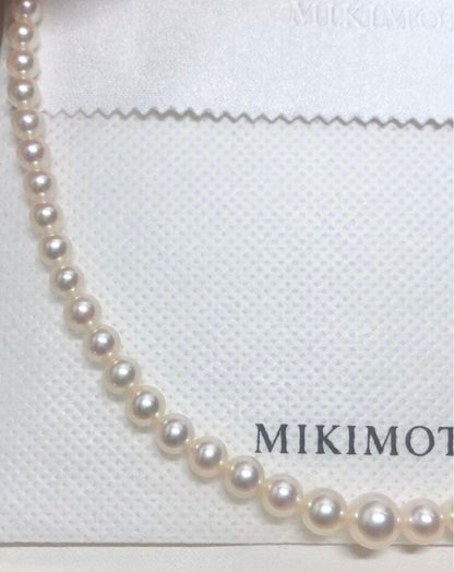 K14wg Mikimoto Akoya baby pearl necklace with gradient sized pearls and 44 cm length on white background