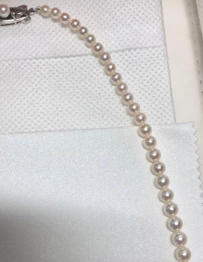 K14wg Mikimoto Akoya baby pearl necklace with gradient sized pearls and 44 cm length on white background