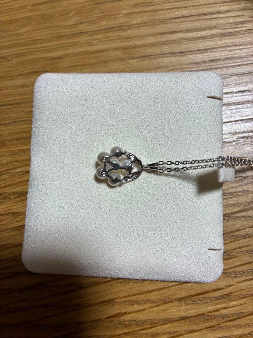 MIKIMOTO Pearl Necklace with silver material and incised silver case shown on white background