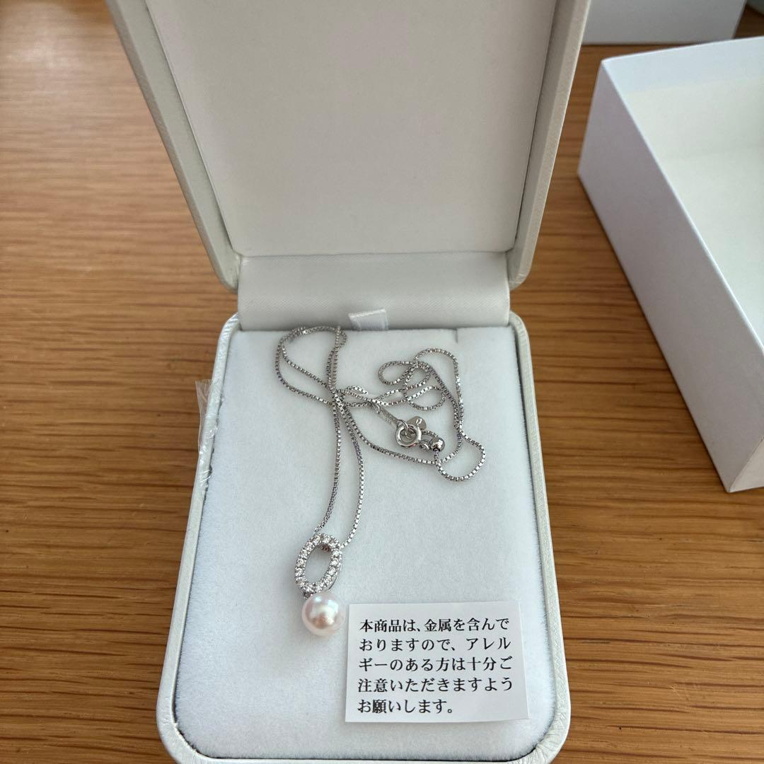 Akoya pearl pendant necklace with 7mm pearl, cubic zirconia accents, and silver 925 rhodium plated chain on white background