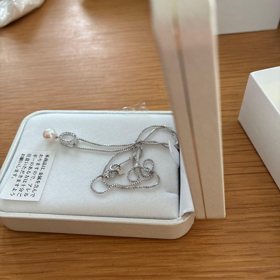 Akoya pearl pendant necklace with 7mm pearl, cubic zirconia accents, and silver 925 rhodium plated chain on white background