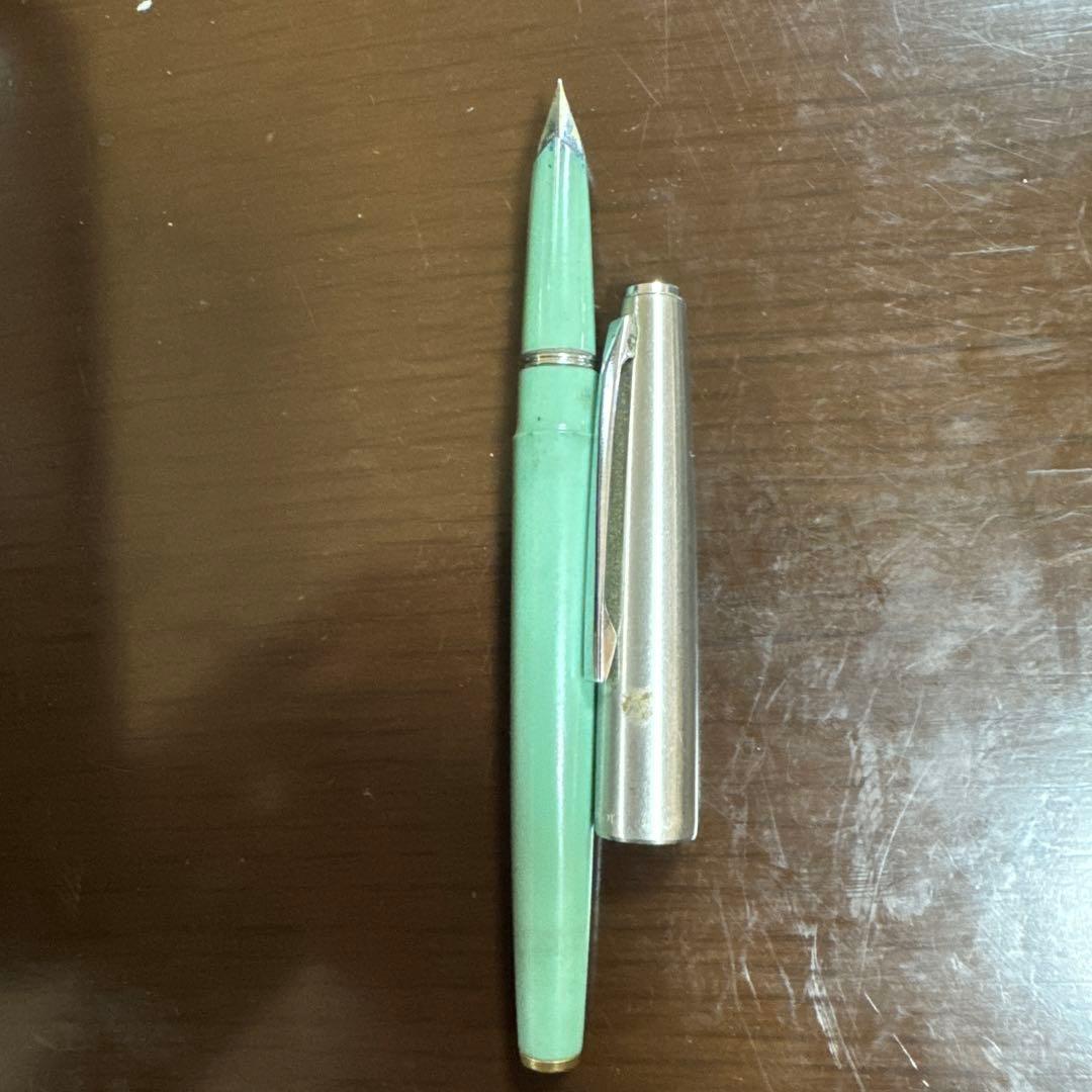Used PILOT green fountain pen with visible scratches, discoloration, and paint peeling