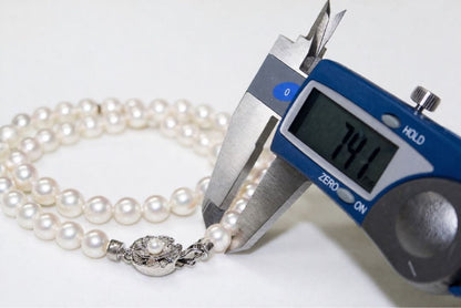 Akoya pearl necklace with 7.4-7.7mm pearls on silver chain, 46 cm length, displayed with box and guarantee card