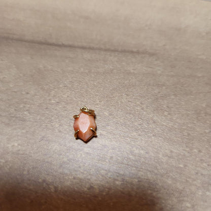 Close-up of a agete necklace charm in excellent condition with a delicate design
