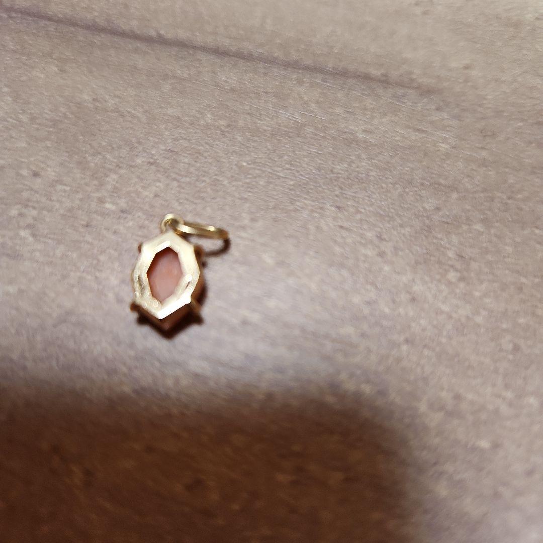 Close-up of a agete necklace charm in excellent condition with a delicate design