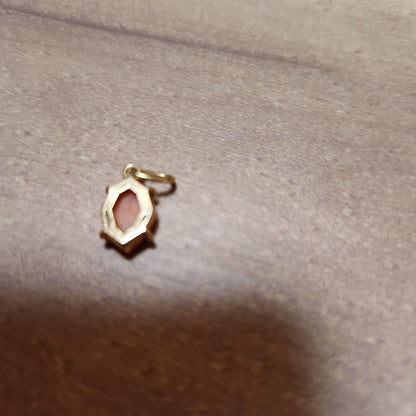 Close-up of a agete necklace charm in excellent condition with a delicate design