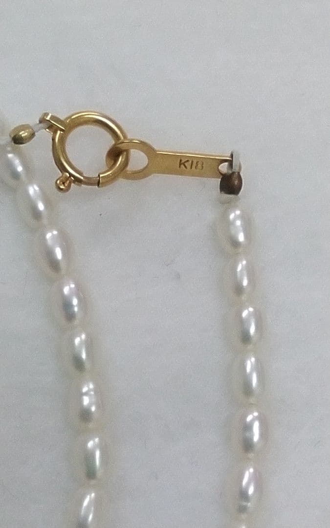 Freshwater Akoya pearl necklace with single 9mm pearl and 18K gold clasp on white background