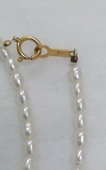 Freshwater Akoya pearl necklace with single 9mm pearl and 18K gold clasp on white background