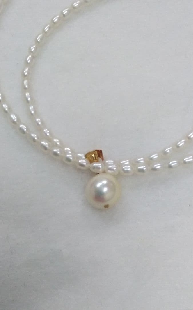 Freshwater Akoya pearl necklace with single 9mm pearl and 18K gold clasp on white background