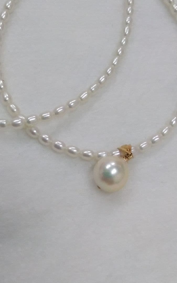 Freshwater Akoya pearl necklace with single 9mm pearl and 18K gold clasp on white background