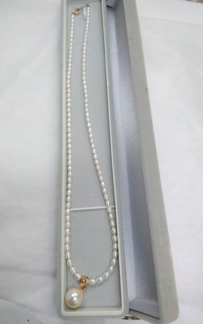 Freshwater Akoya pearl necklace with single 9mm pearl and 18K gold clasp on white background