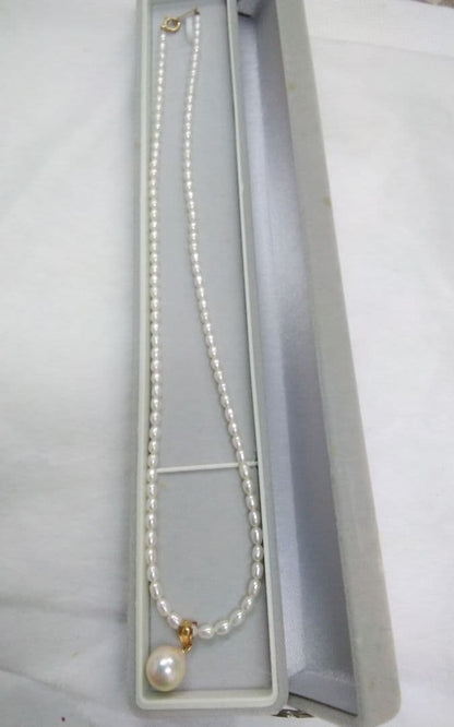 Freshwater Akoya pearl necklace with single 9mm pearl and 18K gold clasp on white background
