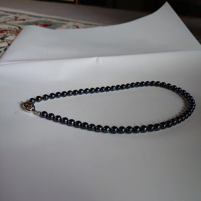 Akoya pearl necklace with blue-black pearls 6.5 to 7 mm and silver S925 clasp on white background