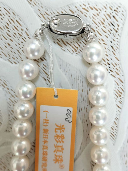 Akoya pearl large round necklace with white pearls and pink-green light interference on a white background
