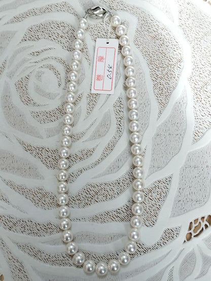 Akoya pearl large round necklace with white pearls and pink-green light interference on a white background