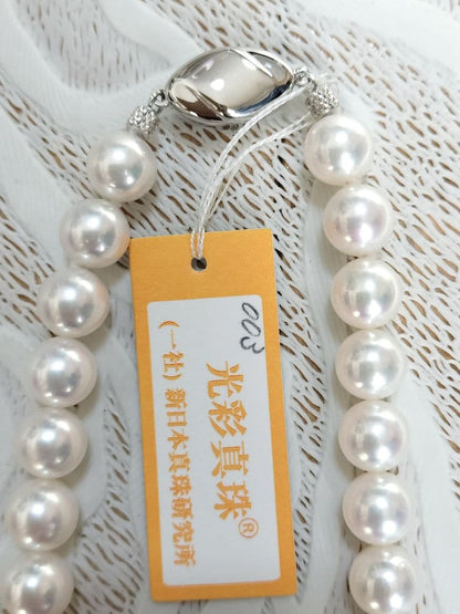 Akoya pearl large round necklace with white pearls and pink-green light interference on a white background