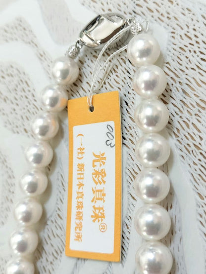 Akoya pearl large round necklace with white pearls and pink-green light interference on a white background